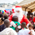 Père Noël entouré d'enfants lors d'une fête.
