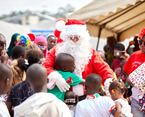 Père Noël entouré d'enfants lors d'une fête.