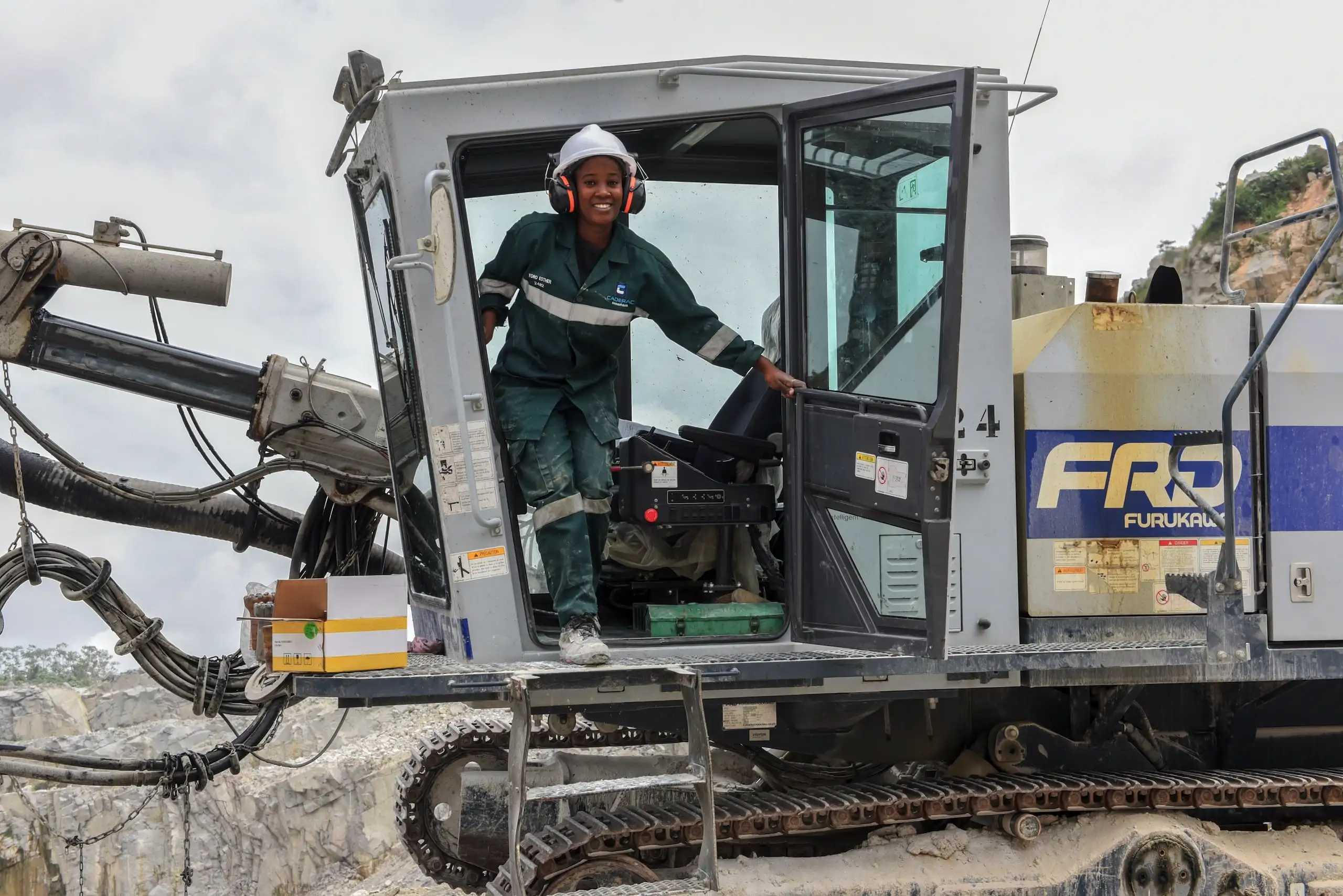 Conducteur souriant dans une cabine d'excavatrice.
