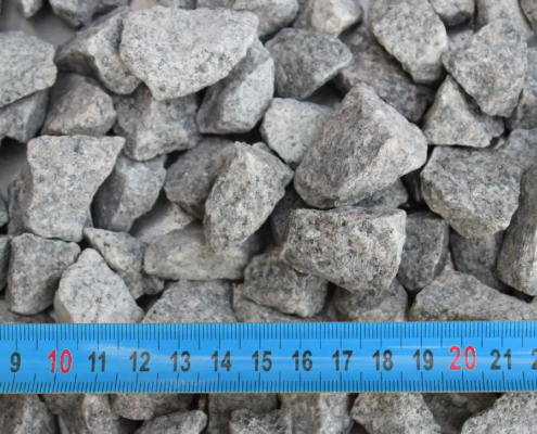Cailloux gris avec règle bleue millimétrique.