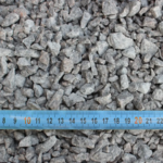 Graviers mesurés avec ruban métrique bleu.