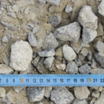 Graviers sur sol avec règle bleue