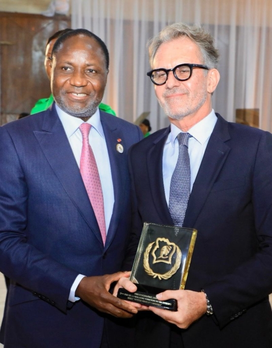 Deux hommes en costume tiennent un trophée.