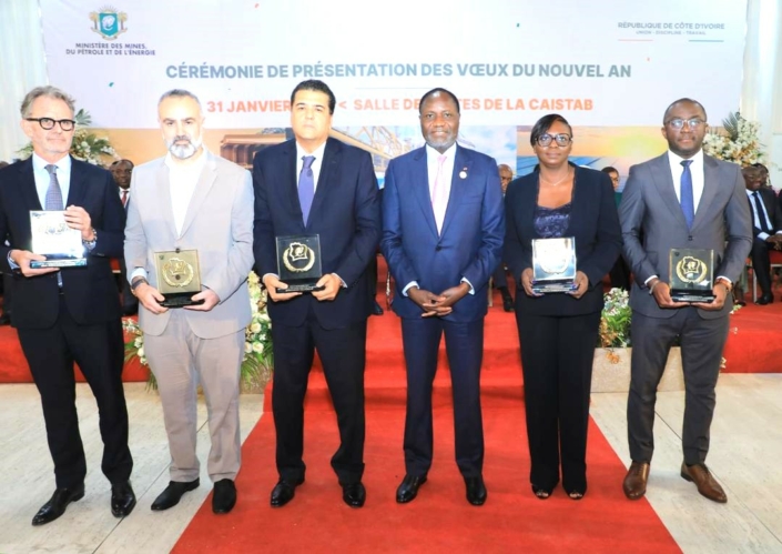 Cérémonie avec six personnes tenant des trophées.