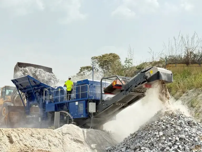 Concasseur mobile en fonctionnement sur site de construction.