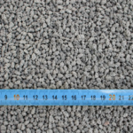 Gravier gris avec mètre ruban bleu.