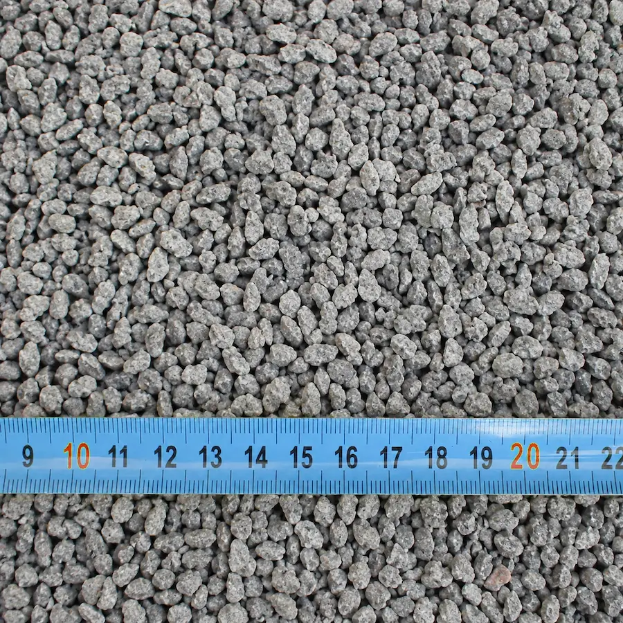 Gravier gris avec mètre ruban bleu.